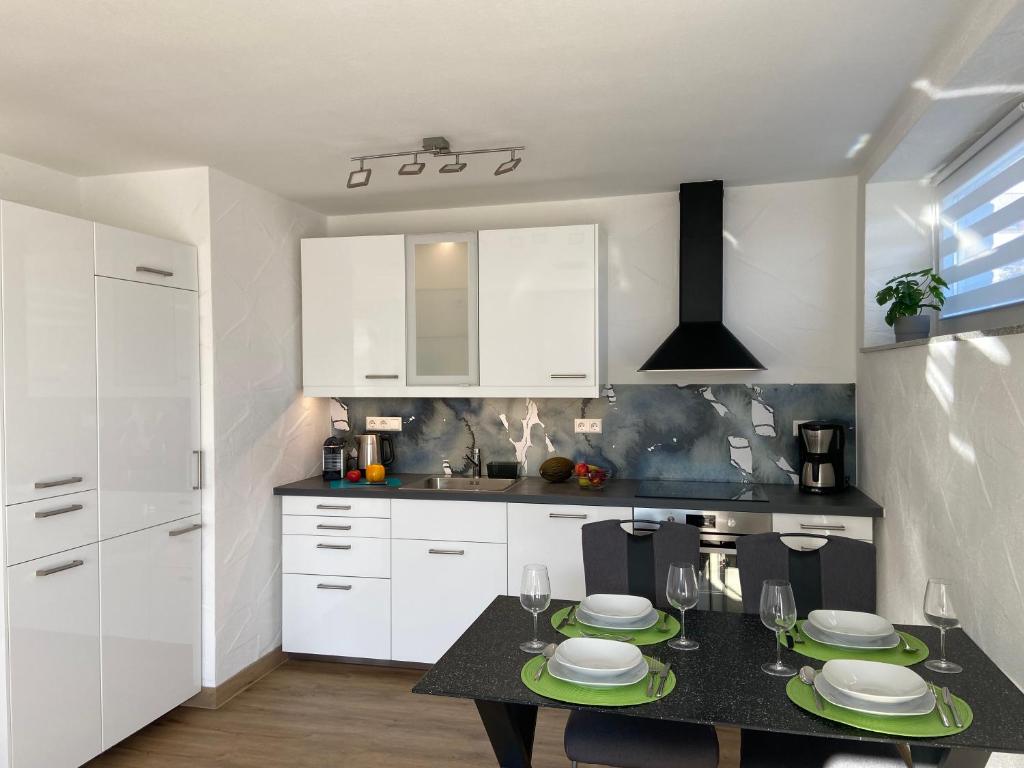 a kitchen with a table with plates on it at Ferienwohnung Zur alten Dorfschule in Lünebach