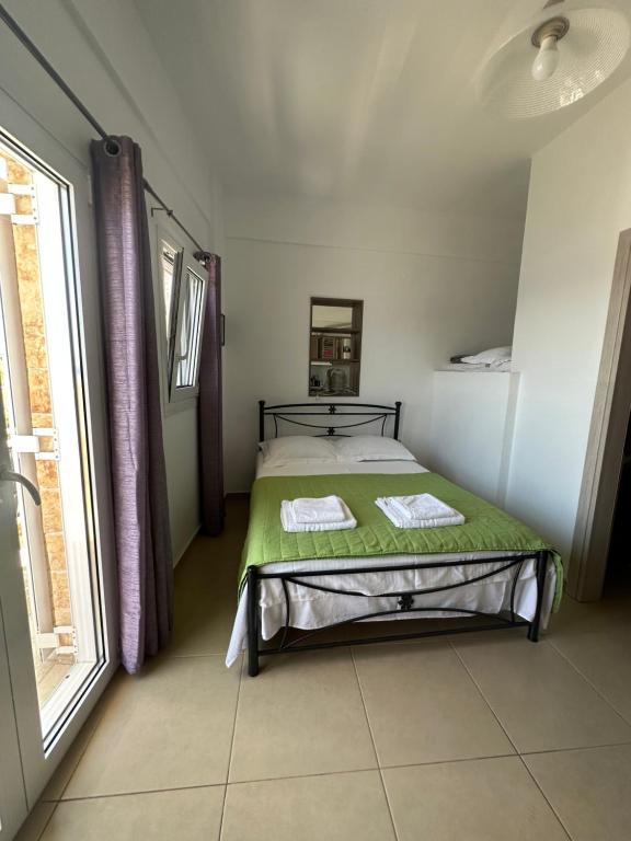 a bedroom with a bed and a large window at House With View in Paránimfoi