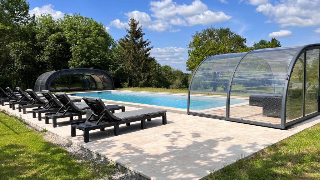 - un groupe de chaises assises à côté de la piscine dans l'établissement La Millière - Gîtes, piscine & campagne, à Le Poiré-sur-Vie