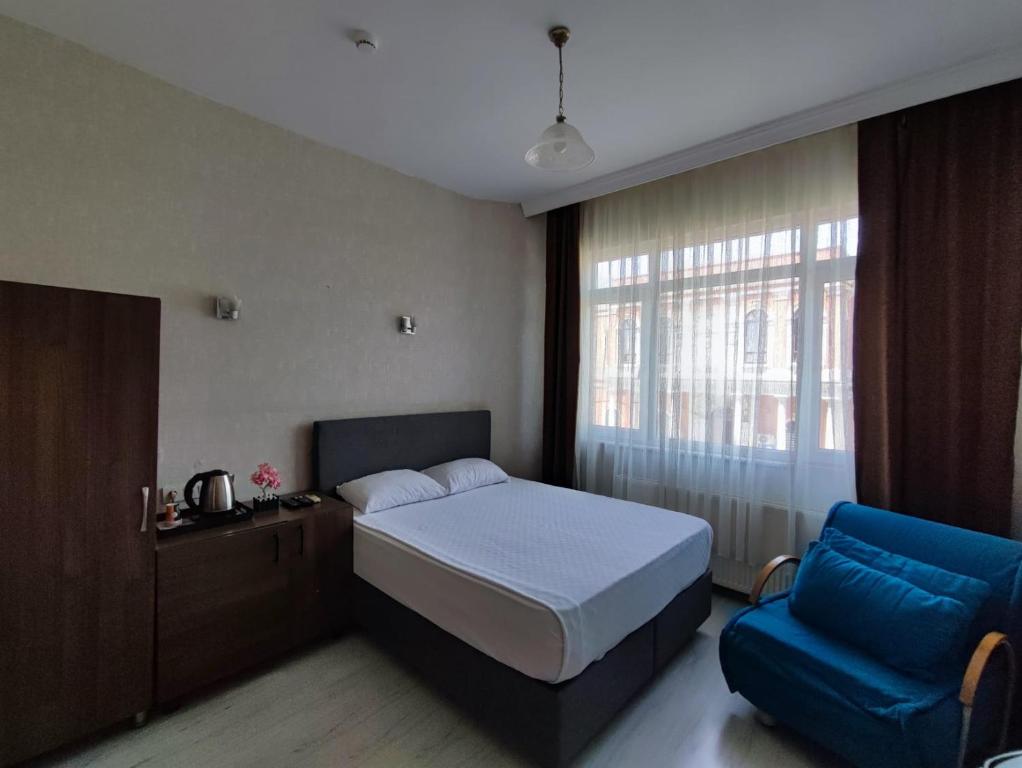 イスタンブールにあるFatih Hotel Erciyesのベッドルーム1室(ベッド1台、青い椅子付)