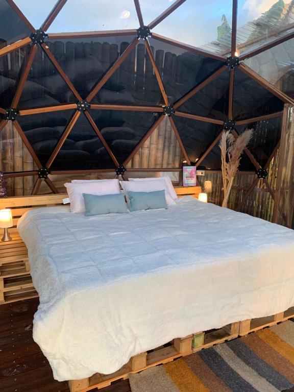 ein Schlafzimmer mit einem großen Bett in einer Jurte in der Unterkunft Happy Glamping Quindio - Tipo Domo Traslúcido in Calarcá