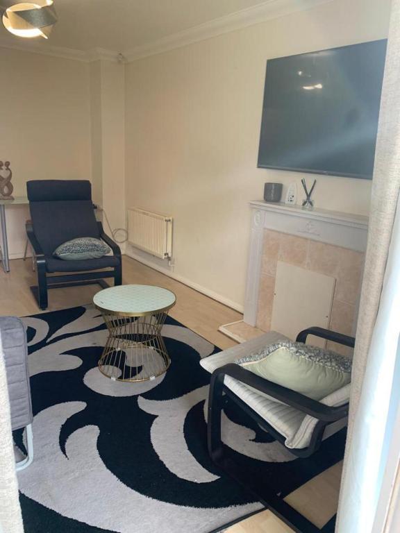 een woonkamer met een tafel en stoelen en een open haard bij Charming 2-Bed House in London in Londen