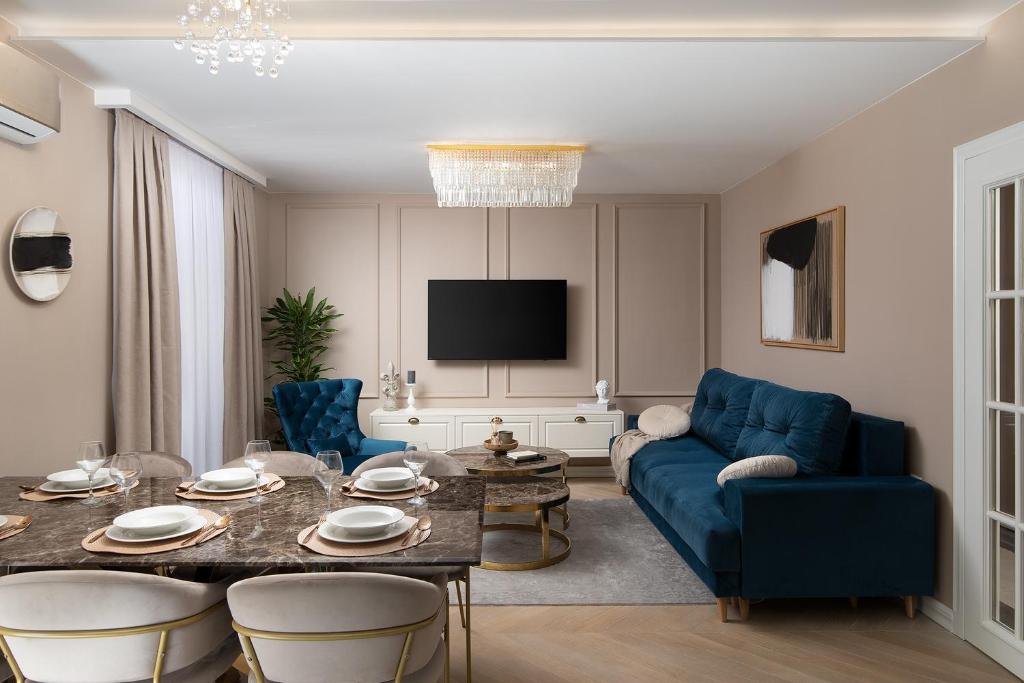 ein Wohnzimmer mit einem blauen Sofa und einem Tisch in der Unterkunft Via Flavia Luxury Accommodation with FREE private parking in Pula