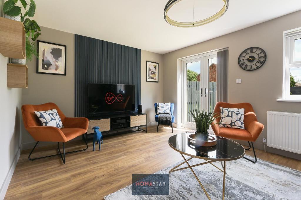 a living room with two chairs and a tv at NOMASTAY, Corporate, Families, Relocation, 3 bed, 2 bath, Parking, next to the hospital, university, city center in Sheffield