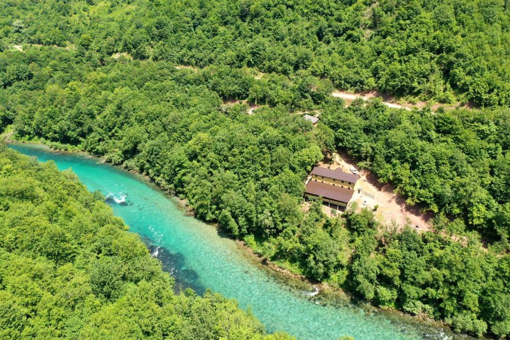 una vista aerea di un fiume alberato e di un edificio di Vucja Gora a Foča