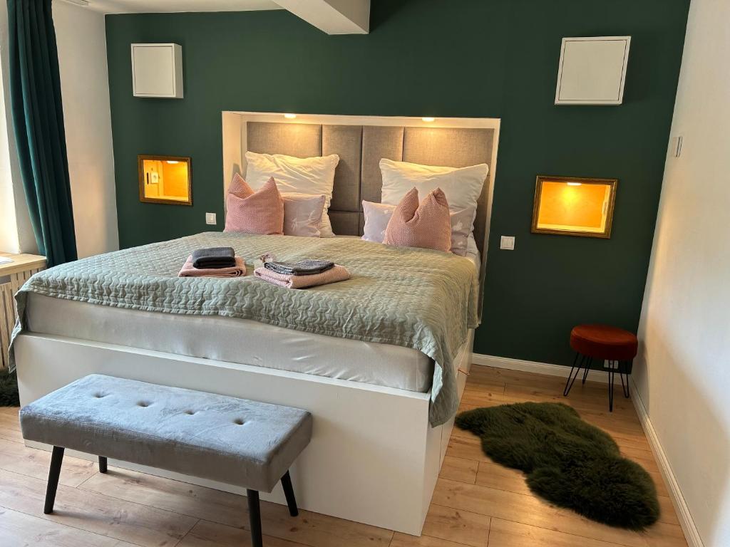 una camera da letto con un grande letto con pareti verdi di Appartement fliegender Hirsch a Bäk