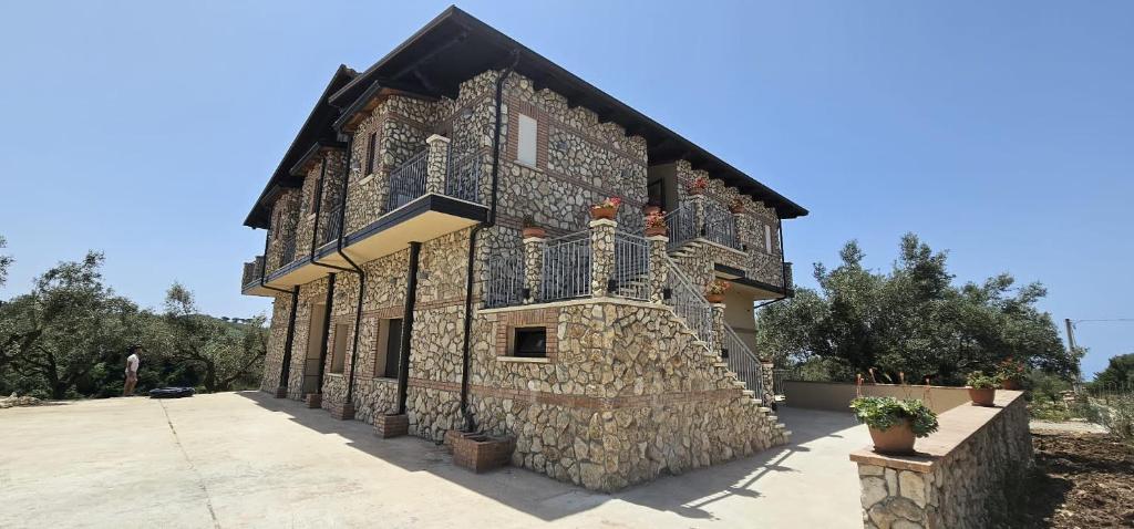 - un bâtiment en pierre avec un balcon sur le côté dans l'établissement Borgo Caridà - Green Family Holidays, à Zaccanopoli
