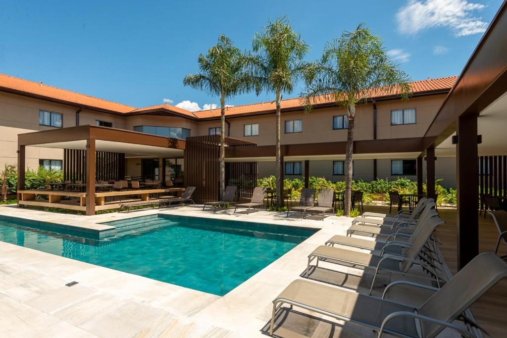 a swimming pool with lounge chairs and a hotel at Fildi Hotel in Sumaré