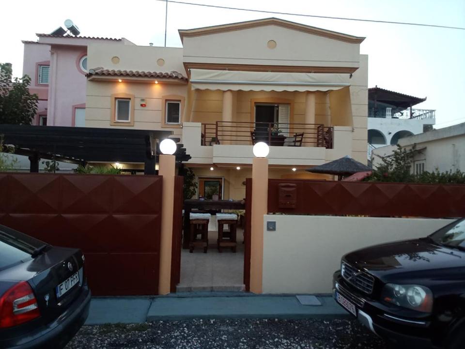 a house with a fence and cars parked in front of it at VILLA AVATOS 2 - Near to the Port of Rafina and the Airport of Athens in Áyios Spirídhon