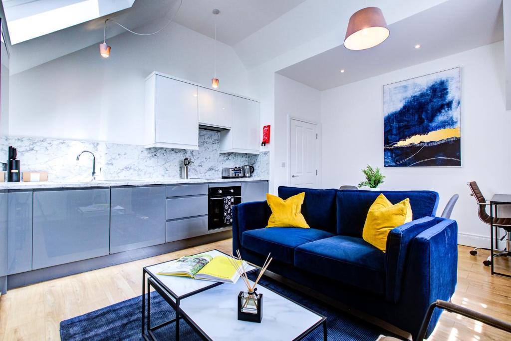 uma sala de estar com um sofá azul e uma cozinha em Hybrid Resi - New Malden near Richmond - Wimbledon em Malden