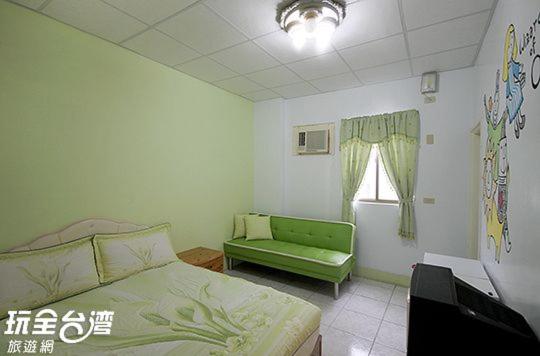 1 dormitorio con 1 cama verde y 1 sofá verde en 綠島 梅蓮民宿 機車 潛水 浮潛, en Isla Verde