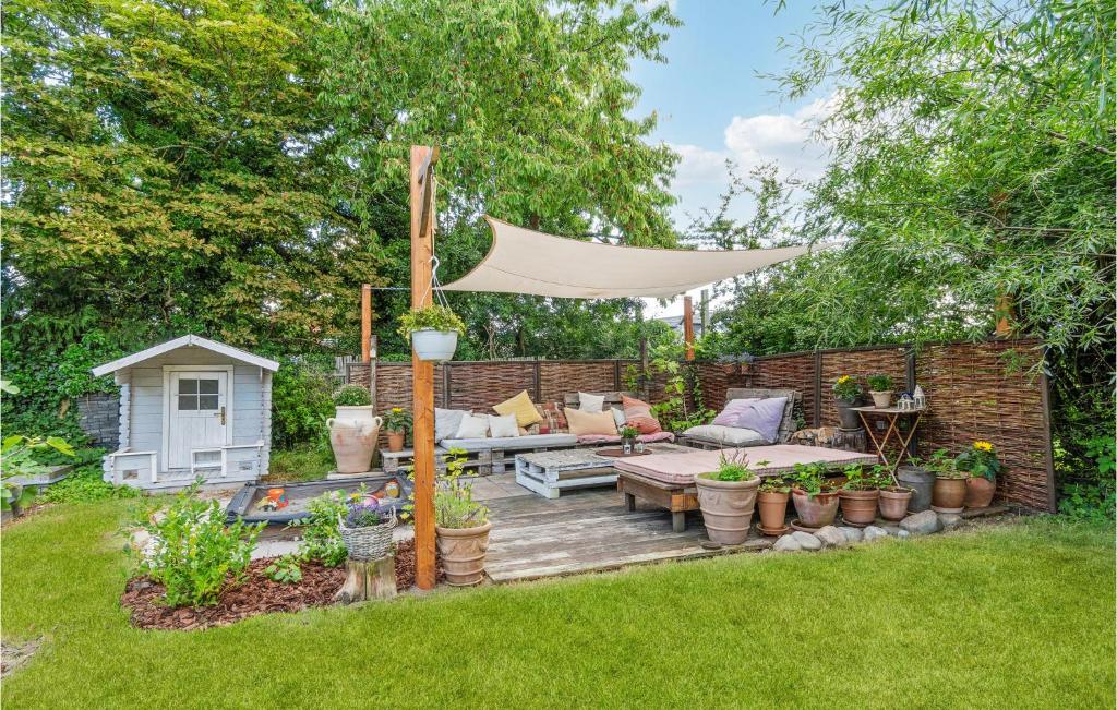 um quintal com um deque de madeira e um guarda-sol no pátio em Lovely Home In Gilleleje With Kitchen em Gilleleje