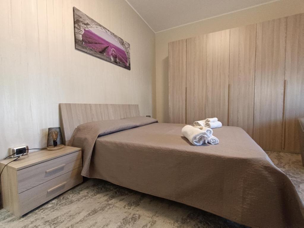 um quarto com uma cama e uma cómoda com toalhas em B&B SOLE E MARE em Rossano