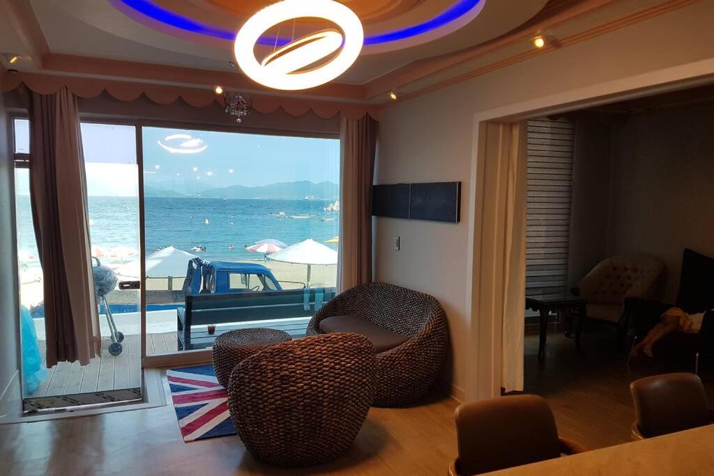 ein Wohnzimmer mit Stühlen und Meerblick in der Unterkunft Private Mosageum in Yeosu