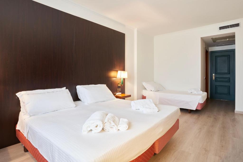 Postel nebo postele na pokoji v ubytování Hotel Cyrano