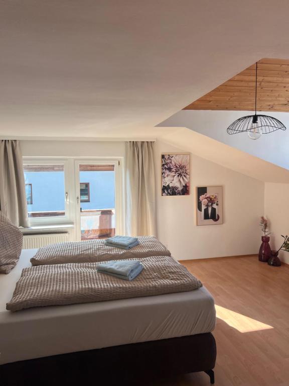 a bedroom with two beds and a large window at Mountain View Apartment in Innsbruck