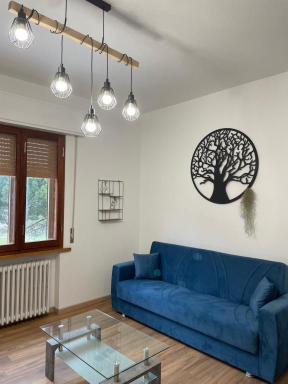 uma sala de estar com um sofá azul e uma mesa de vidro em Tulip’house em Sant'Albino