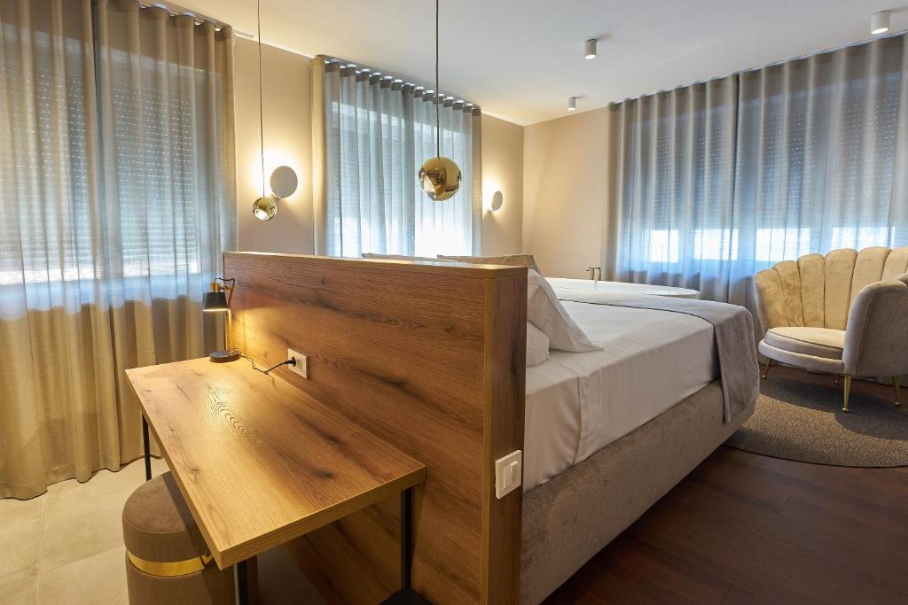 1 dormitorio con 1 cama, escritorio y ventanas en Dolcemente Garni Hotel Superior, en Izola
