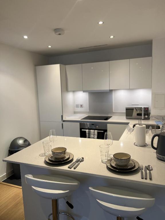 a kitchen with a counter with plates and glasses on it at Luxurious 1 Bedroom Apartment In Croydon in Croydon