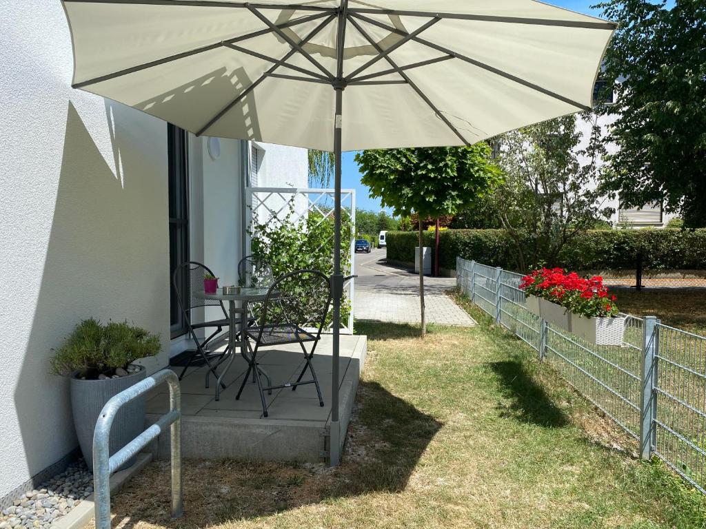 une table et un parasol dans l'herbe dans l'établissement Helles Appartement mit Terrasse, à Friedrichshafen