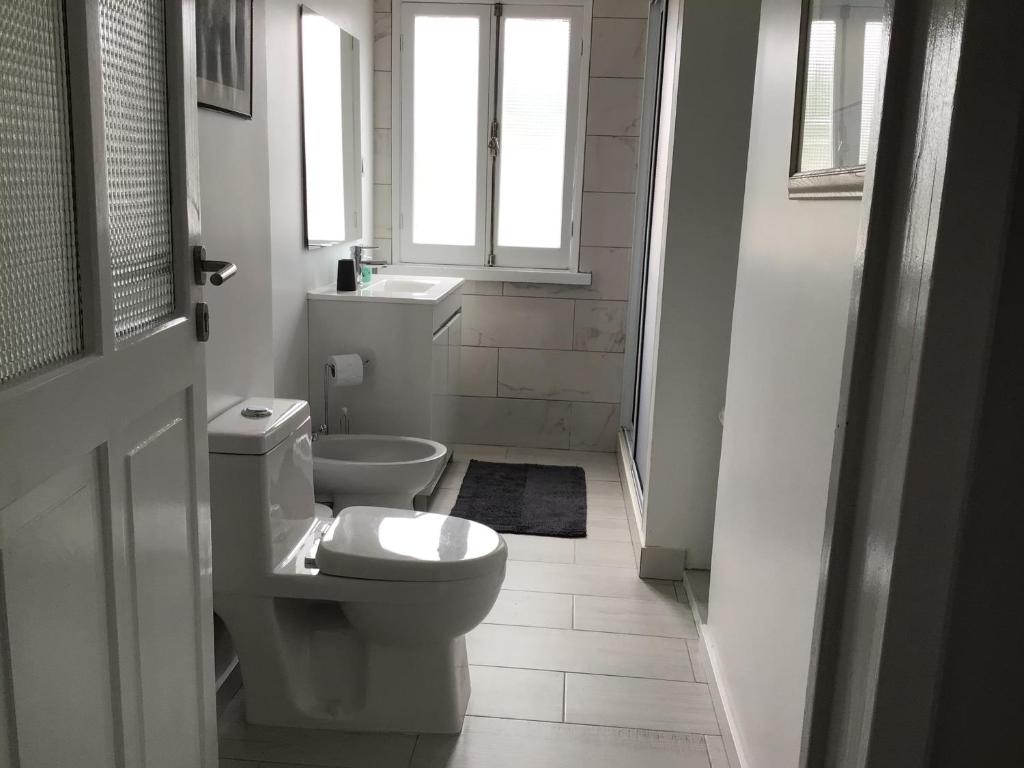 a white bathroom with a toilet and a window at Pousada da Vila in Vila Franca do Campo