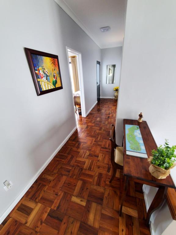 a hallway with a dining room table and wood floors at Pousada da Vila in Vila Franca do Campo