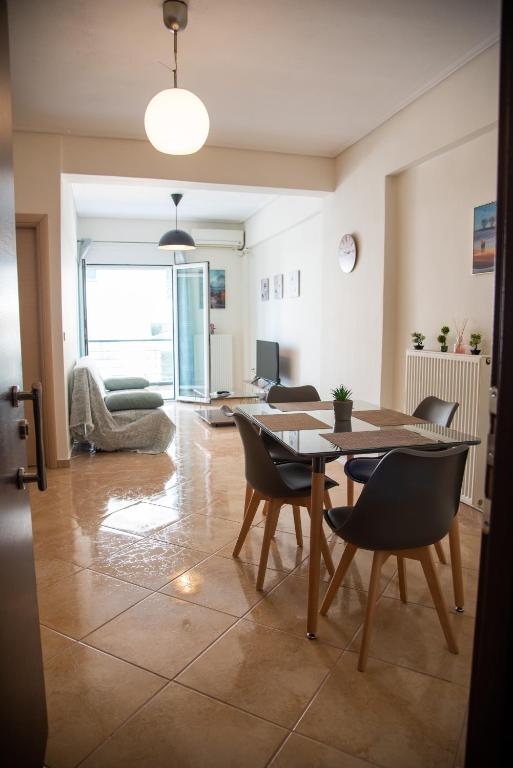 een woonkamer met een tafel en stoelen bij Modern apartment at Nea Artaki in Nea Artaki