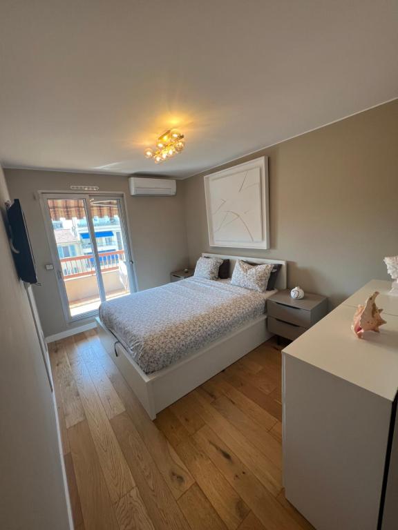 um pequeno quarto com uma cama e uma janela em Beautiful Arty Apartment em Nice