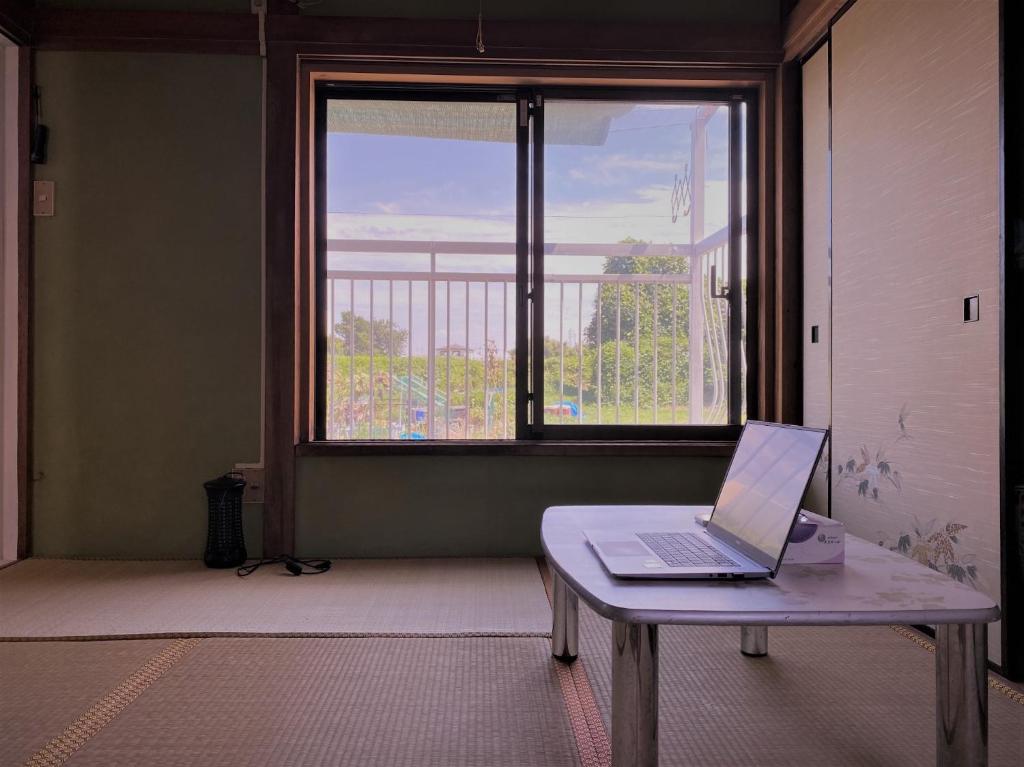 einen Laptop auf einem Tisch vor einem Fenster in der Unterkunft Shonan no Oka no Villa - Vacation STAY 24013v in Fujisawa