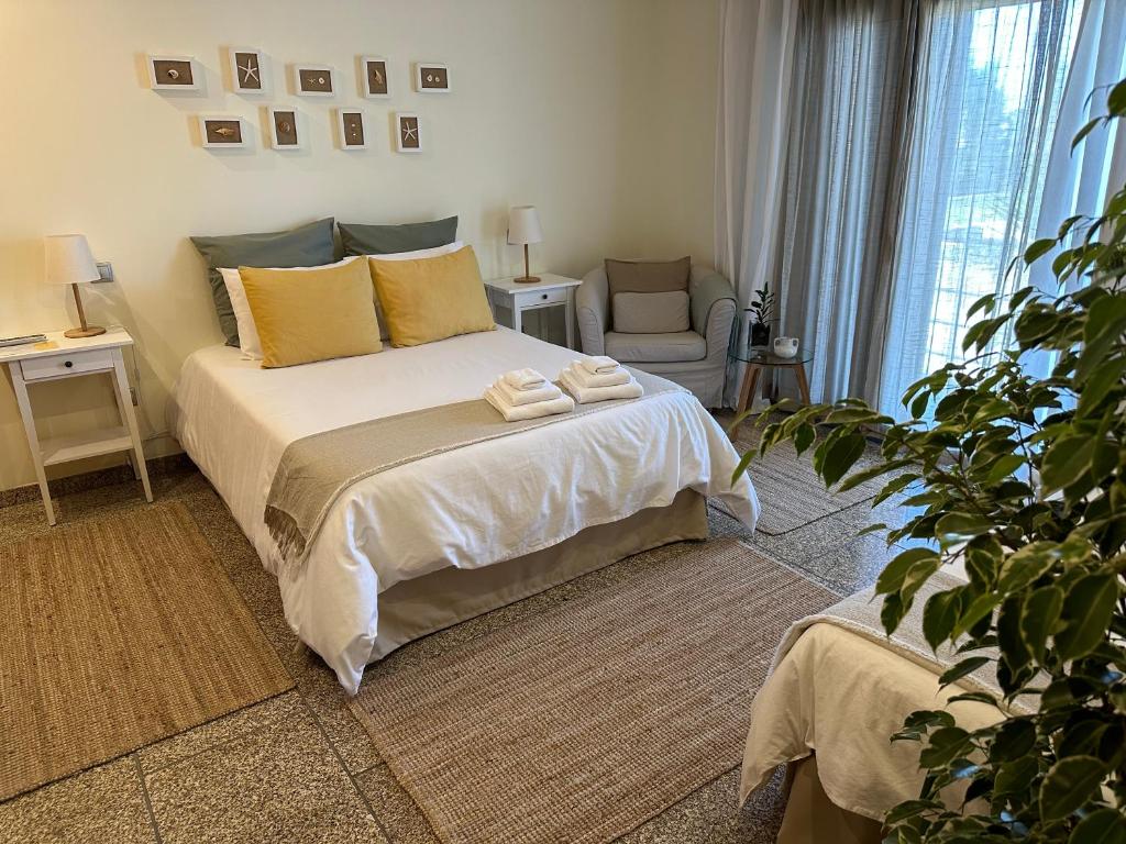 a bedroom with a bed with two towels on it at Casa de Praia Guest House in Labruge