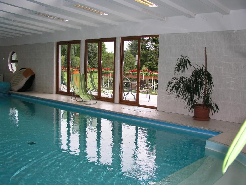 a large swimming pool in a building with a pool at Villa Vlasta in Karlovy Vary