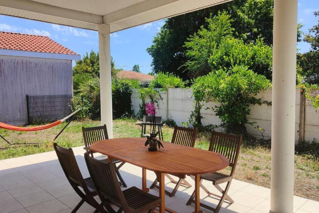 une table et des chaises en bois sur une terrasse dans l'établissement La maison du bonheur, à Biscarrosse