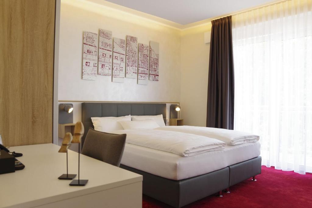 um quarto de hotel com uma cama e uma secretária em Hotel am Waldkasino em Erfurt