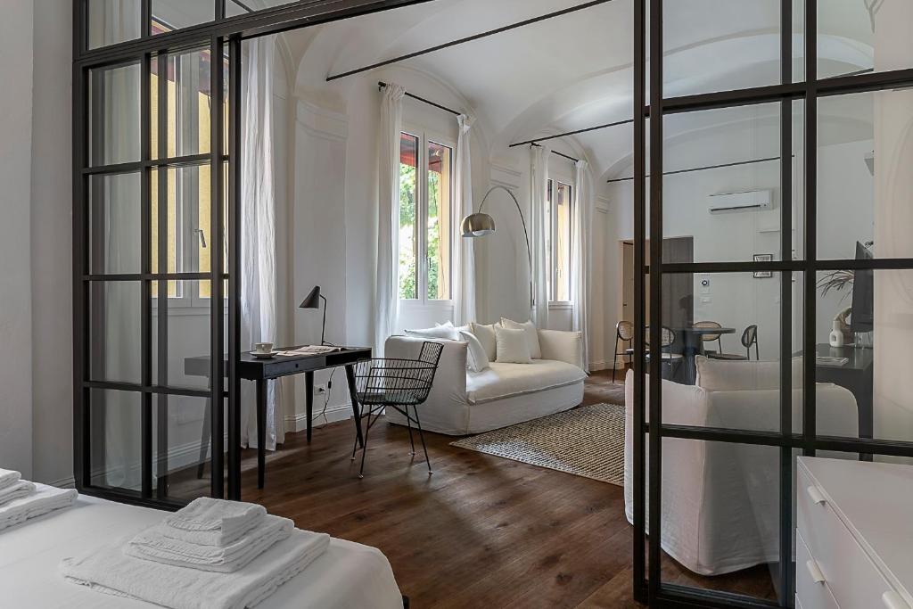 un soggiorno con divano bianco e specchio di Everyday Apartments Corte Petroni a Bologna