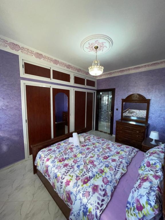 Un dormitorio con una cama grande y una lámpara de araña. en Superbe maison avec terrasse à hay mohamedi, en Agadir