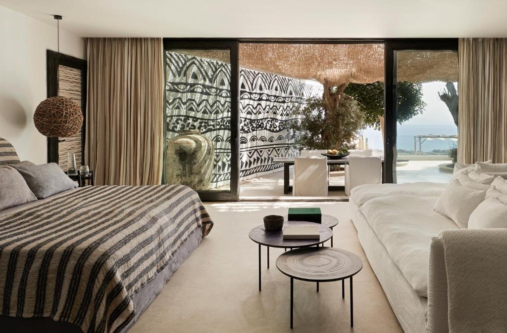 una camera con letto, divano e tavolo di Myconian Panoptis Escape, a member of Small Luxury Hotels of the World a Elia Beach