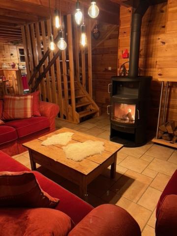 a living room with a fireplace and a coffee table at Chalet Authentique MARIOUCHKA - 4 étoiles, avec Sauna, À 150M DES PISTES - Domaine Alpe d'Huez in Villard-Reculas