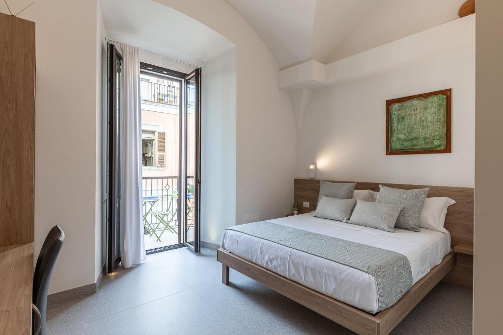 ein Schlafzimmer mit einem Bett und einem großen Fenster in der Unterkunft Dimora dei Celestini in Manfredonia