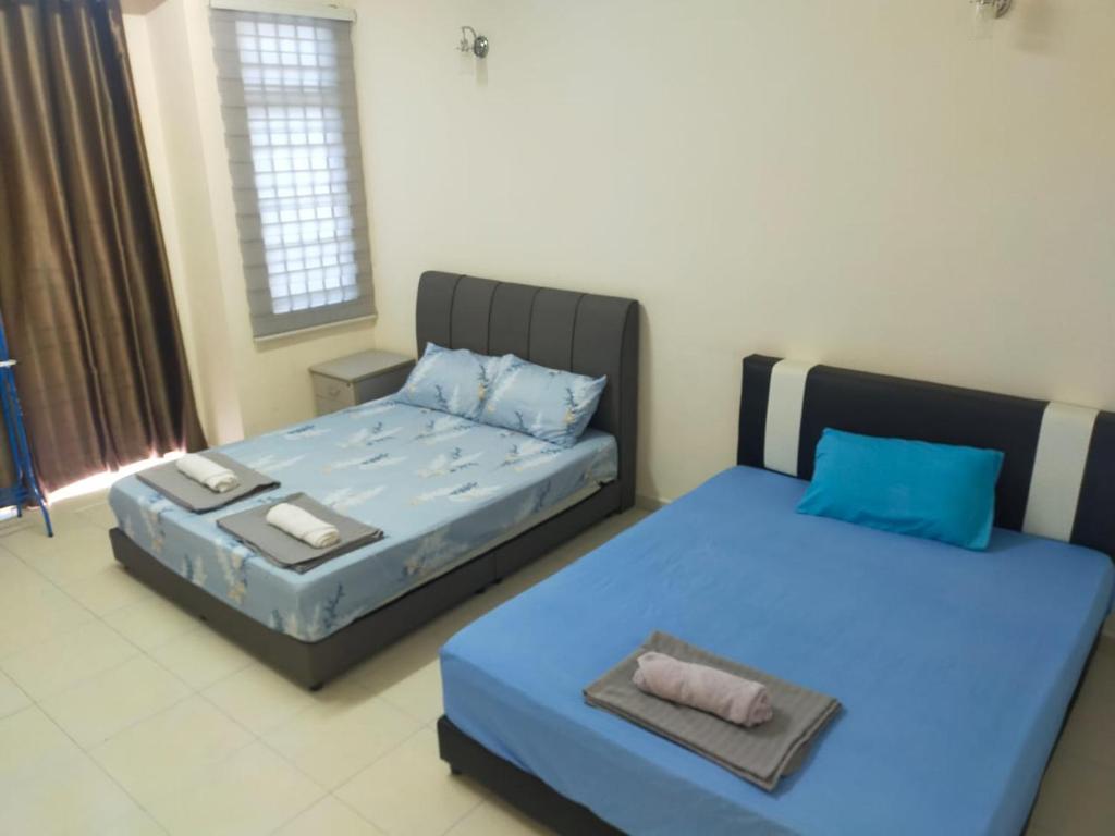 1 Schlafzimmer mit 2 Betten und blauen Kissen in der Unterkunft Cheerful 3-Bedroom Residential Home with Free WIFI in Butterworth