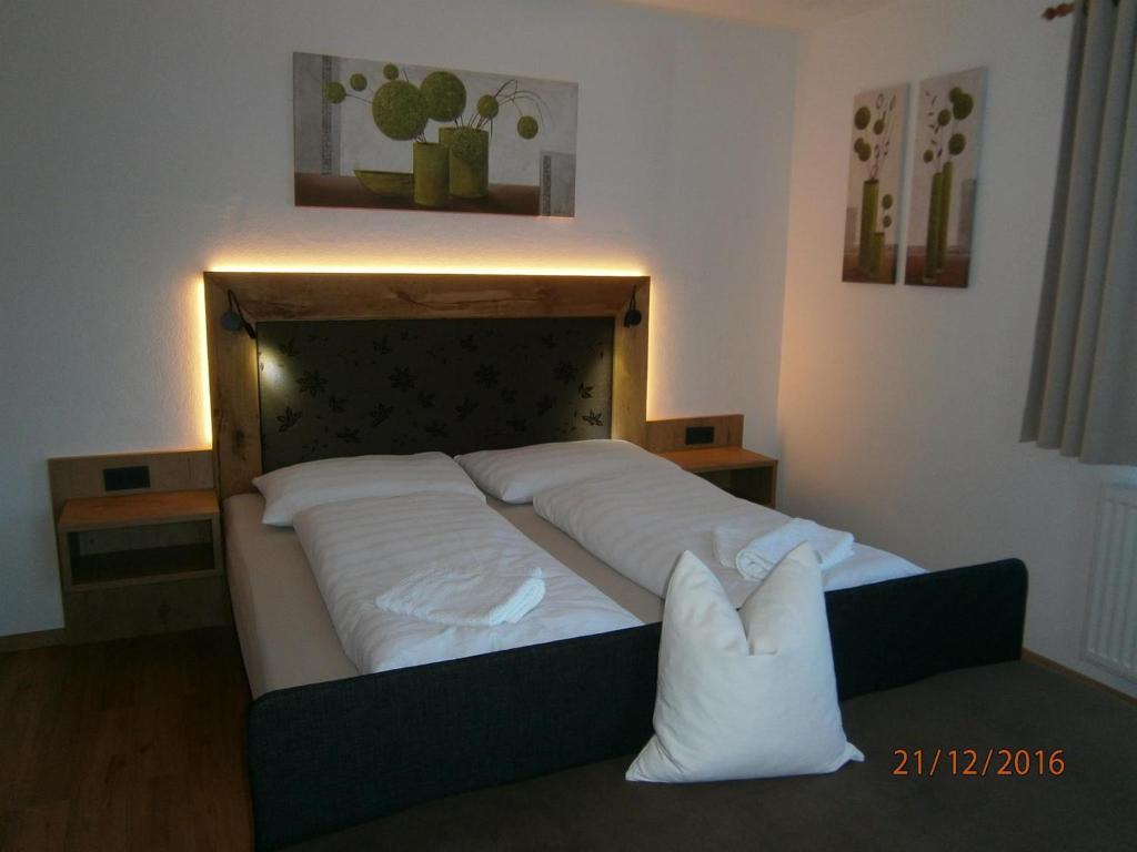 ein Schlafzimmer mit einem großen Bett mit weißen Kissen in der Unterkunft Appartements Schitter in Flachau