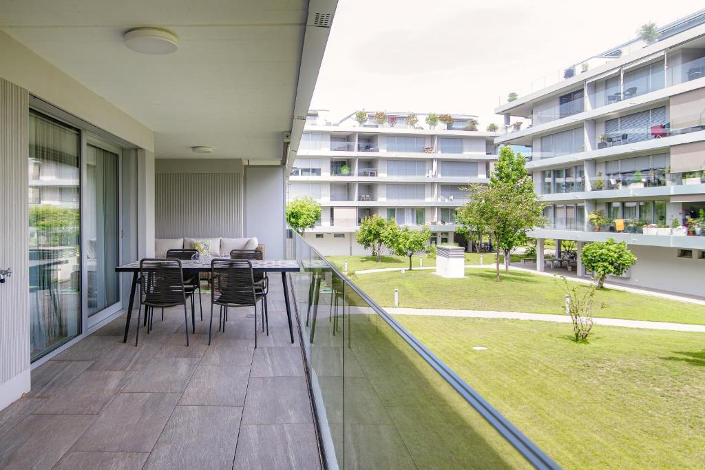 Cet appartement dispose d'un jardin et d'un balcon avec une table et des chaises. dans l'établissement Suite Parco Lago by Quokka 360 - Terraced flat close to Lido Locarno, à Locarno