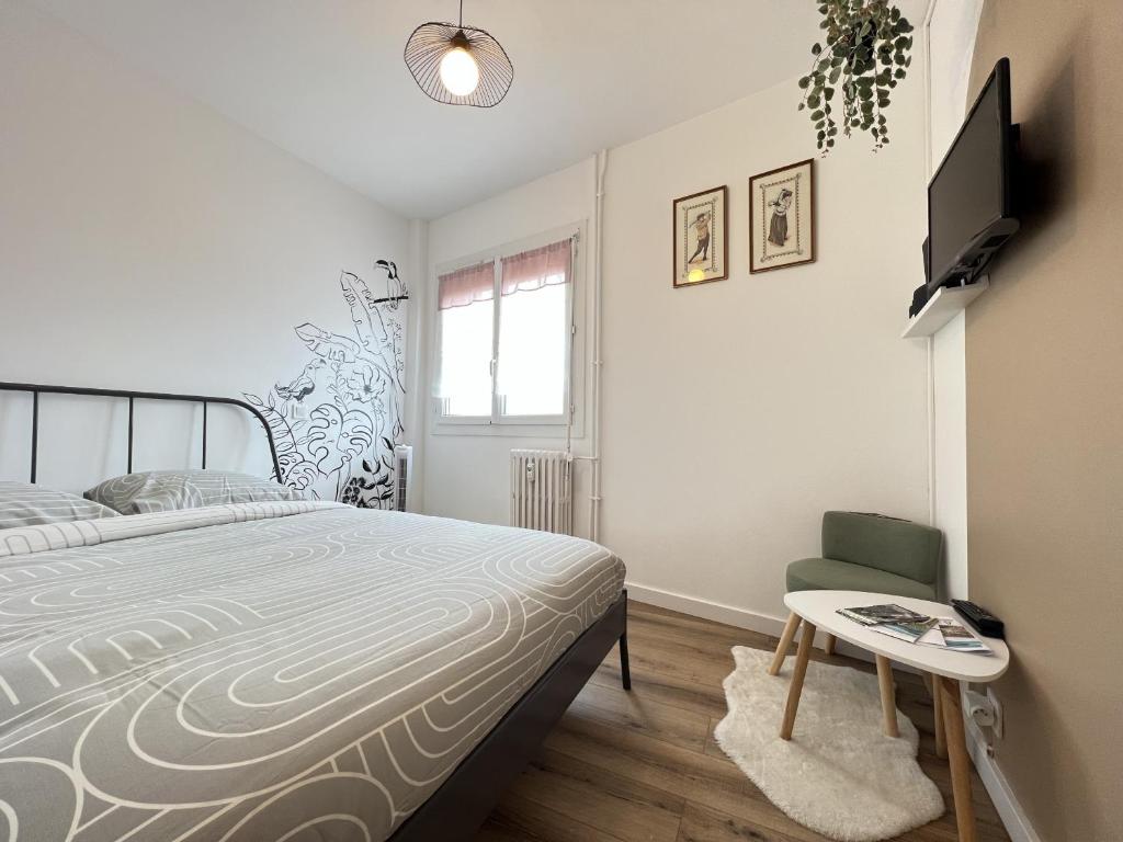 1 dormitorio con 1 cama, TV y silla en Le Toucan - Joli studio proche Tram & centre-ville, en Toulouse