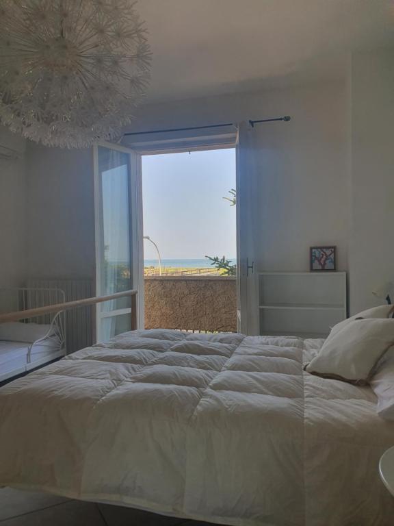 - une chambre avec un grand lit et une grande fenêtre dans l'établissement NEL BLU, à Porto SantʼElpidio