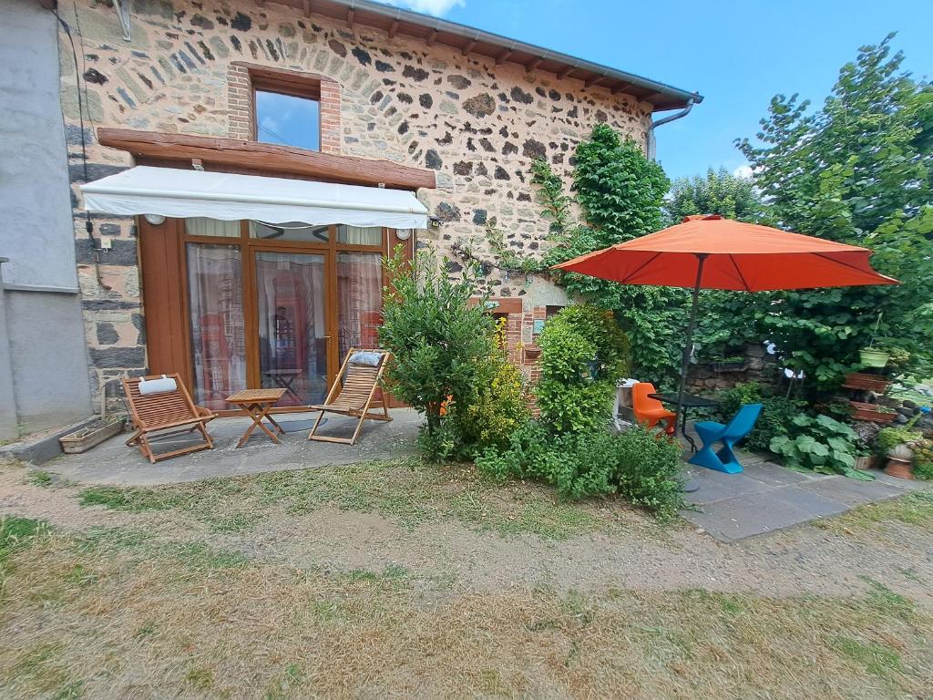 une terrasse avec une table, un parasol et des chaises dans l'établissement Le Céleste, à Châtel-Guyon