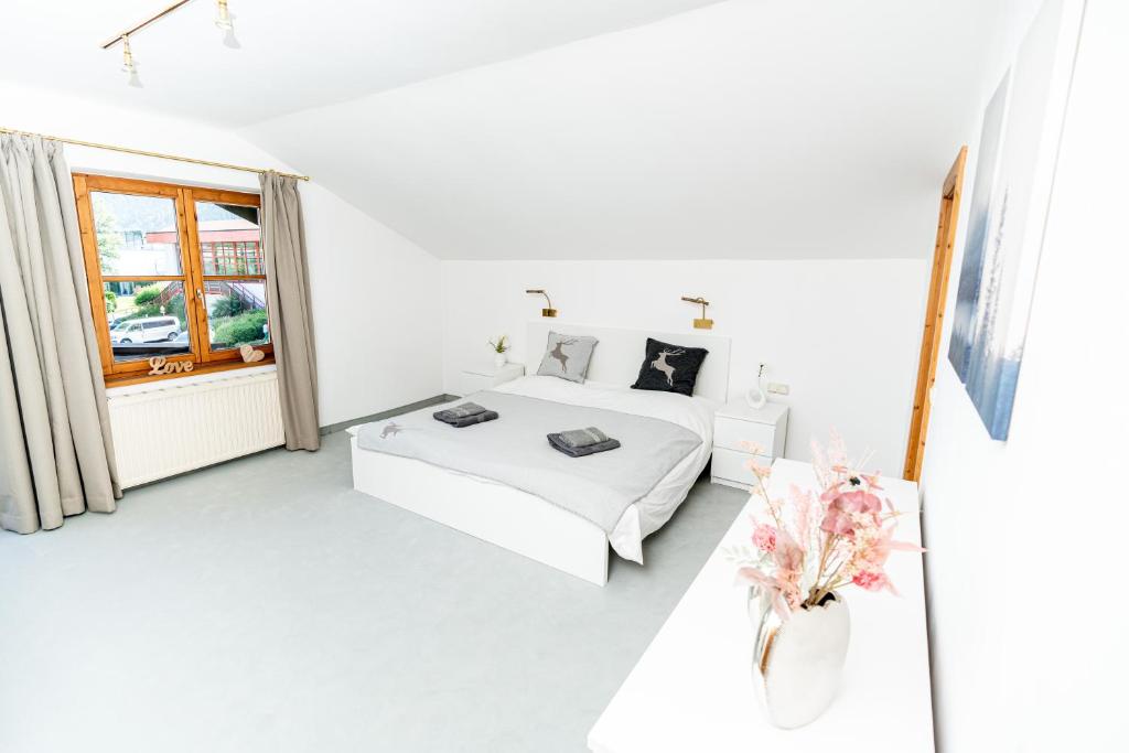 ein weißes Schlafzimmer mit einem Bett und einem Fenster in der Unterkunft City Center Apartment Kitzbühel in Kitzbühel