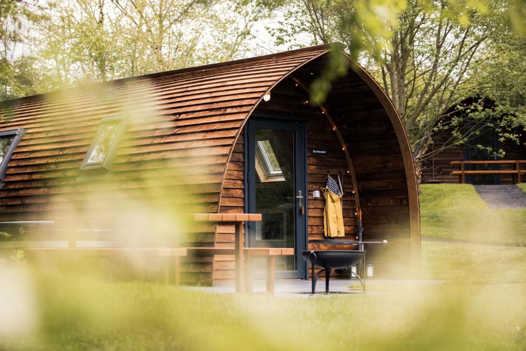 a small log cabin with a door and a chair at Wigwam Holidays Forcett Grange in Richmond