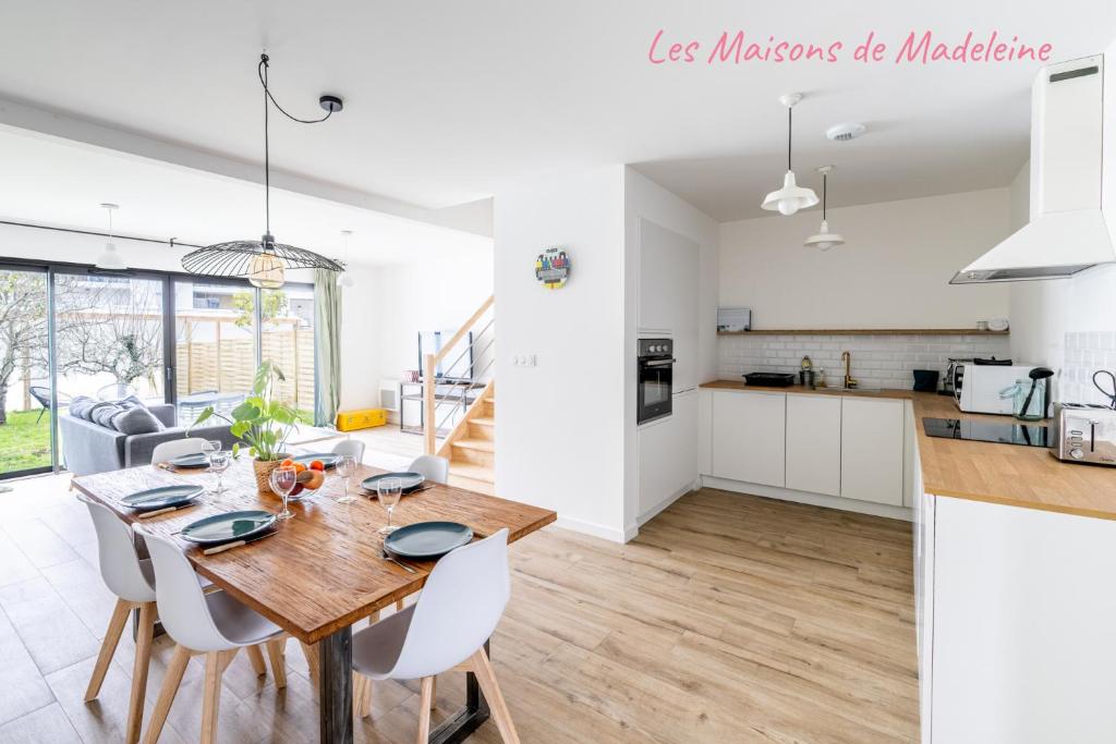 Il comprend une cuisine et une salle à manger avec une table et des chaises en bois. dans l'établissement Maison avec jardin 15 min hyper centre Nantes, à Orvault