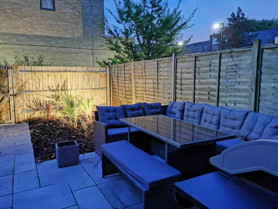 patio ze stołem, krzesłami i ogrodzeniem w obiekcie Modernistic 4 BR house with a garden in Islington w Londynie
