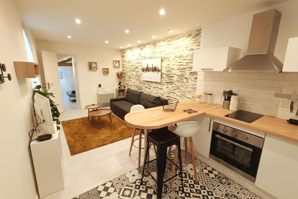 een keuken en een woonkamer met een houten tafel in een kamer bij Douceurs Angevine in Angers