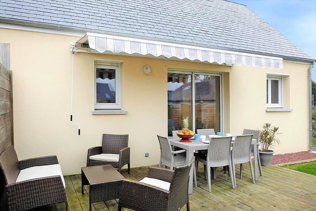 a patio with a table and chairs and a house at Baie du Mont Saint Michel / Gîte de la Vaquerie 23 in Vains